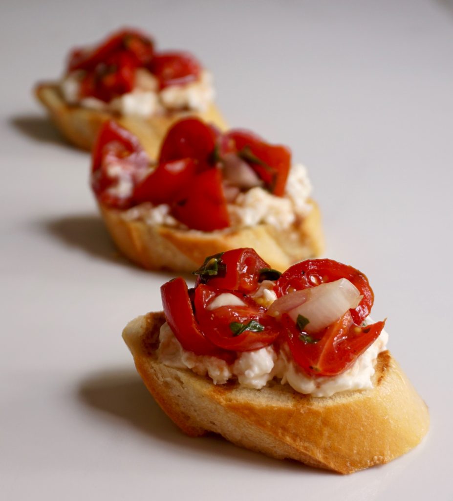 Burrata Bruschetta is a toasted baguette served with burrata tomatoes.