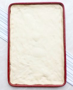 Pizza dough in baking sheet